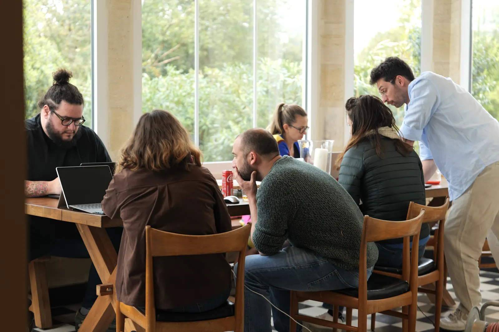 Une session Zevra : un petit groupe travaille sur ses ordinateurs autour des tables